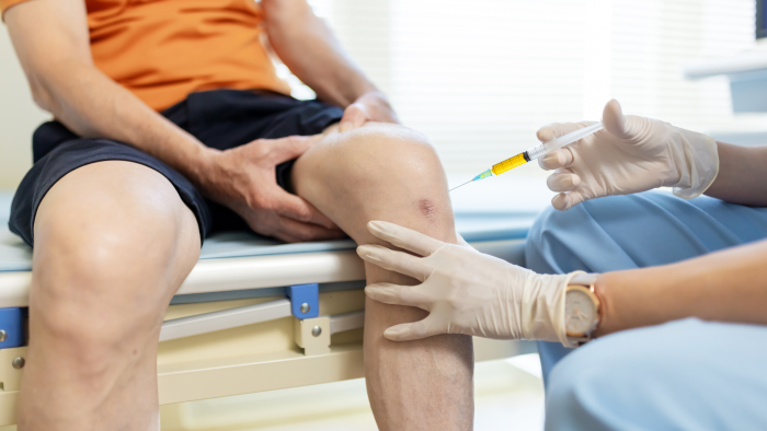 Physician inspecting a patient's knee