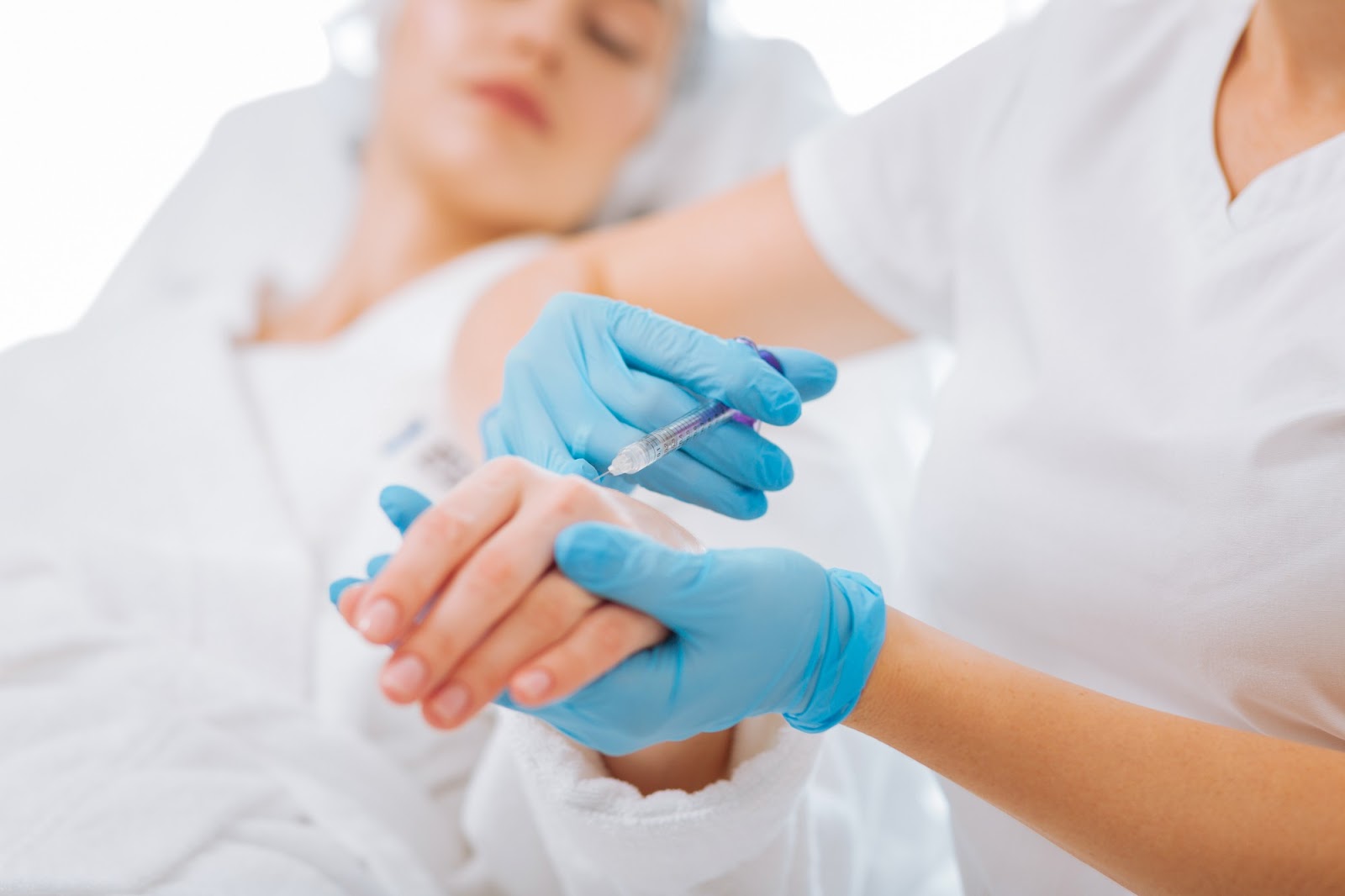 Patient receiving Radiesse injection for hand rejuvenation.