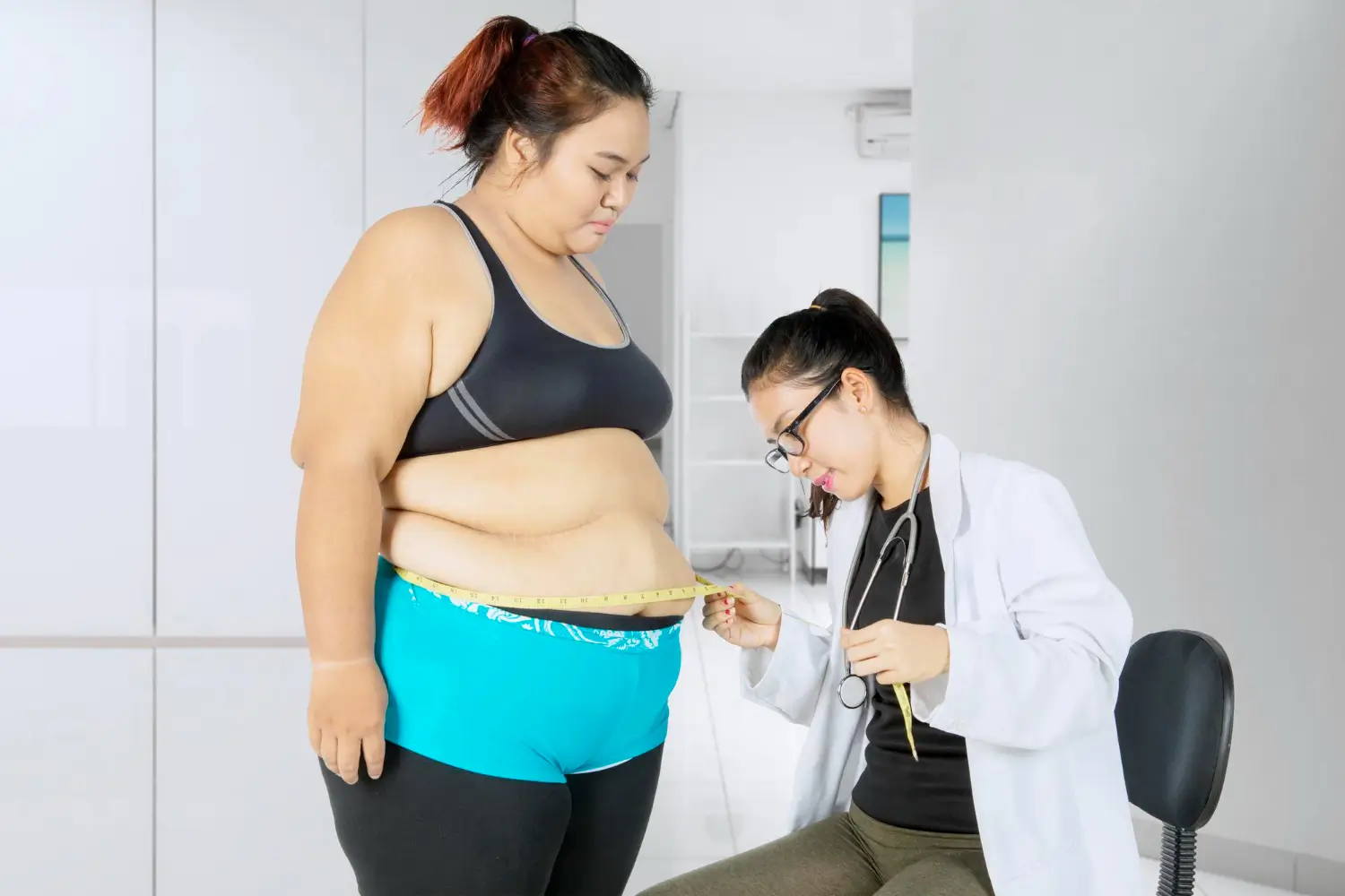 Doctor checks the patient's body for any excess fats.