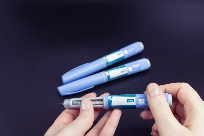Readying a syringe for drug administration from a vial, signifying proper medication preparation.