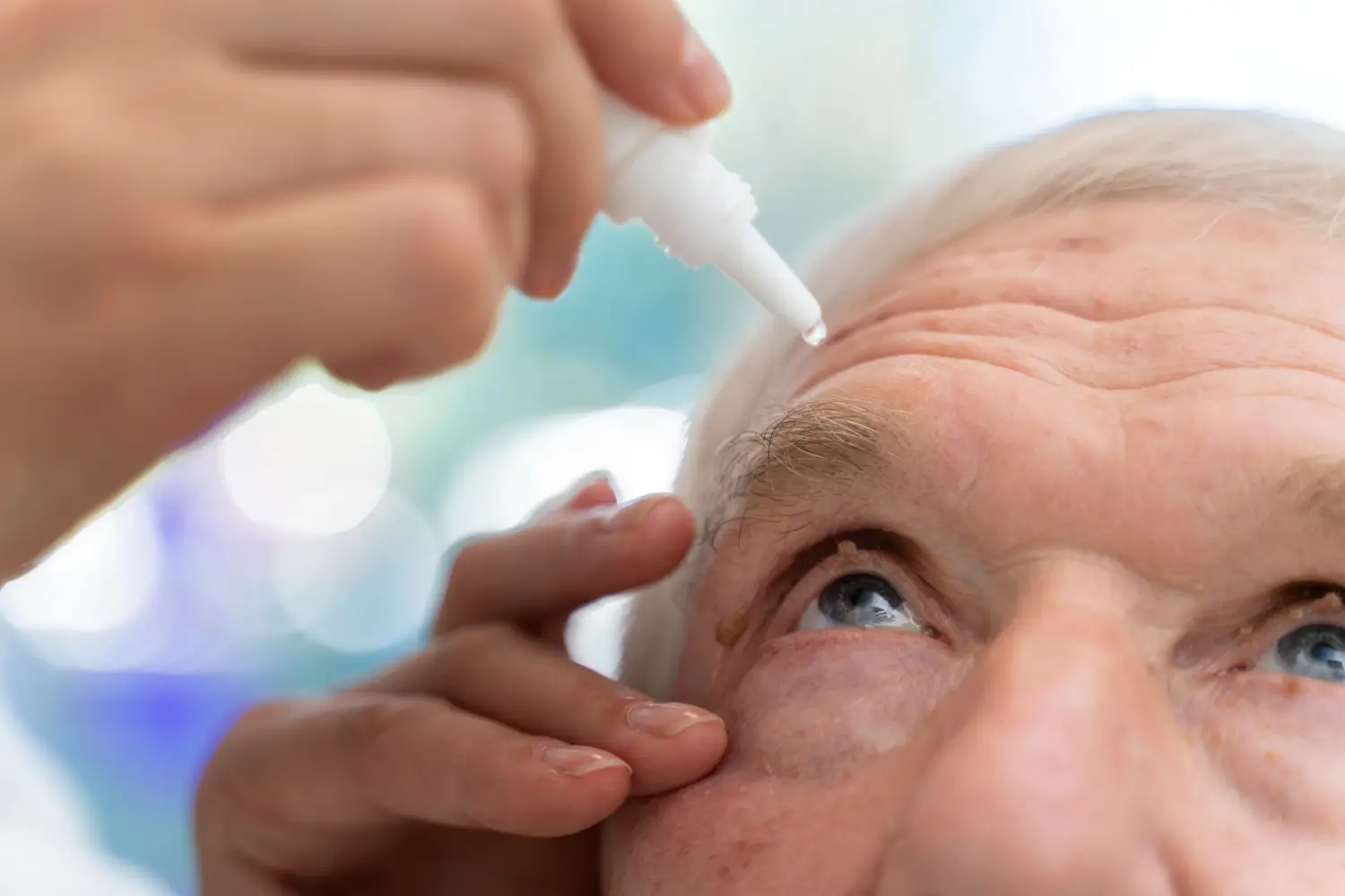 helping the patient put drops into his eyes