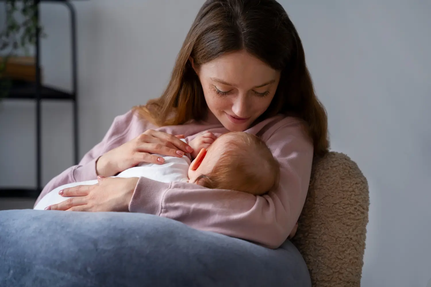 Mom gently breastfeeds her baby with a supportive nursing pillow.